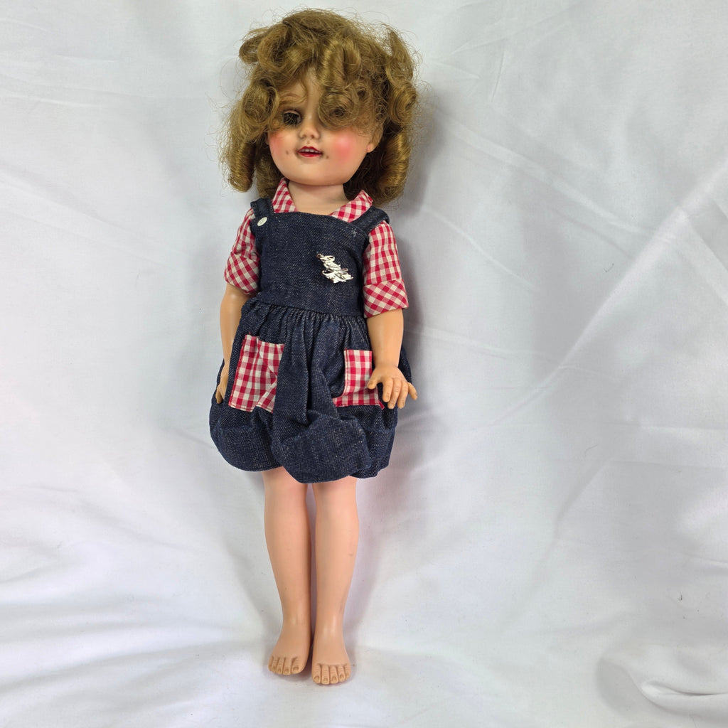 Vintage 1950s hard plastic girl doll in red gingham blouse and denim jumper skirt