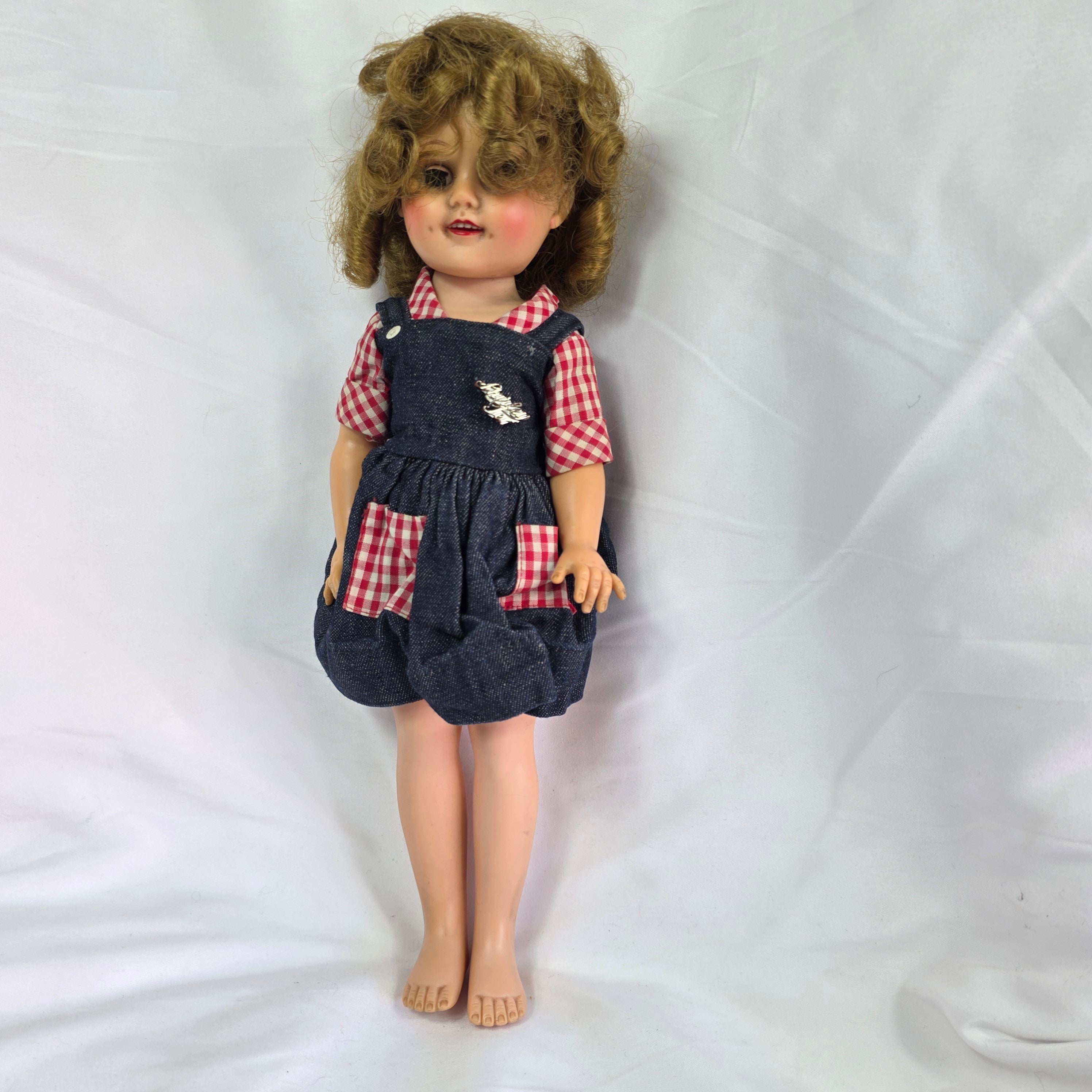 Vintage 1950s hard plastic girl doll in red gingham blouse and denim jumper skirt